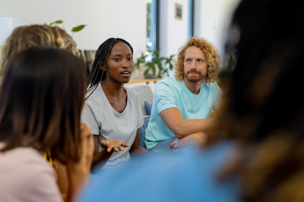 Woman speaking in a group therapy session. Showcasing outpatient care at Bayside Behavioral Health.